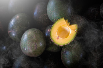 Half cut avocado Put on an avocado pile. Close up shot. focus on half cut avocado. Top view.