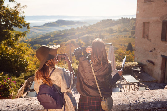 Womans enjoying a sunny day on travel and take picture on landscape