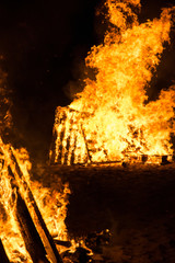 Cone shaped bonfires with big flames and wood