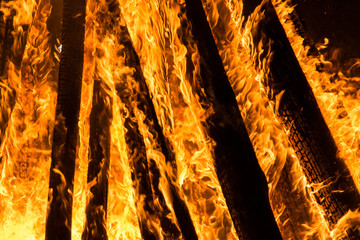 Cone shaped bonfire with big flames and wood