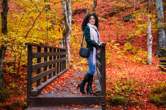 Young woman on a small wooden bridge in a forest at autumn. River and camping place Grza near the Paracin in Serbia.