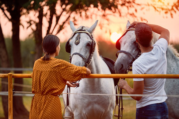  girl and man with their horse in evening sunset