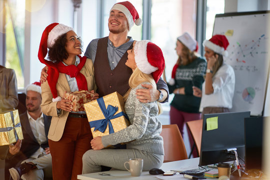 Christmas Party In Office. Friends In Santa Hat Celebrating Christmas In Office