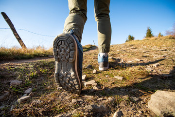 Woman hiker walking through the mountains with professional boots