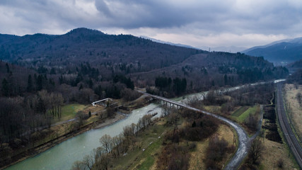 Fototapeta na wymiar Aerial drone view of green mountain, pine forest, river and village. Carpathian, Ukraine.