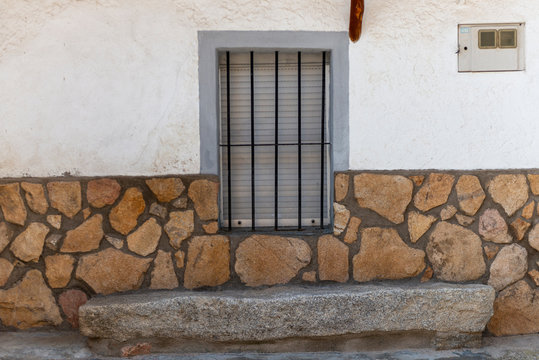 PARED DE PIEDRA Y VENTANA CON VERJAS DE FORJA