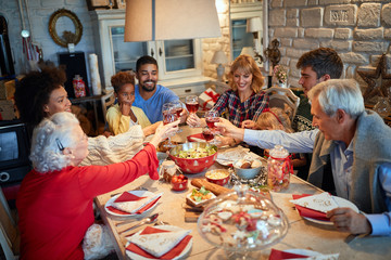 Family having Christmas dinner at home with happy friends