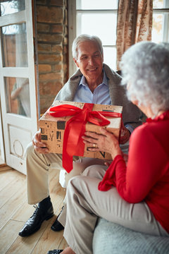 happy family open presents on Christmas morning.Senior man and woman Exchanging Christmas Gifts