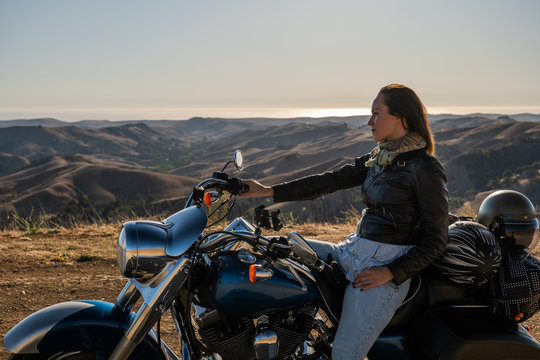 Woman biker sitting on her motorcycle