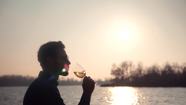 Man Drinking Wine On Sunrise.Winemaker Tasting Wine.Man Holding Glass Of White Wine.Close Up Winemaker Sommelier Smelling At Sunset.Vintner Check Wine Glass.Winegrower Evaluating Color And Degustation
