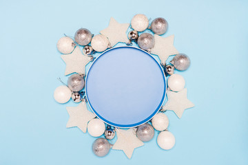 2020 Christmas decor toys wreath, white balls, stars on blue background. Copy space. Elegant New Year`s Holiday decorations concept flat lay.