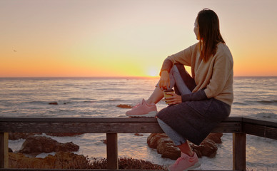 Fototapeta na wymiar Woman enjoying sunset near ocean