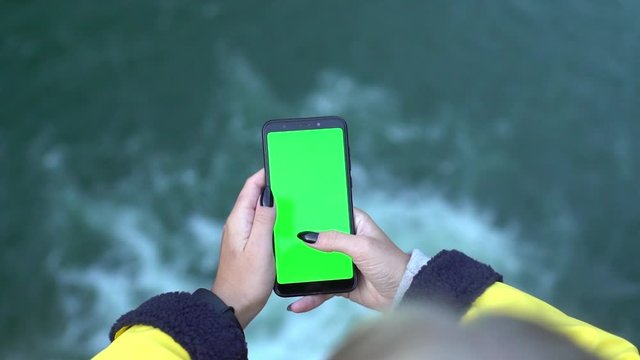 Close up of a woman's hand holding smartphone with vertical green screen chromakey tracking matte on waterfall nature beauty chroma key smartphone technology cell phone street touch message display