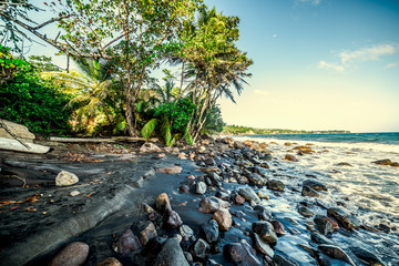 Rocks and dark sand in Grande Anse beach in Guadeloupe