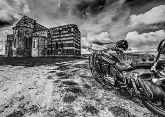 XII century church and classic motorcycle in black and white