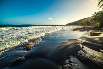 Dark sand in Grande Anse beach in Guadeloupe