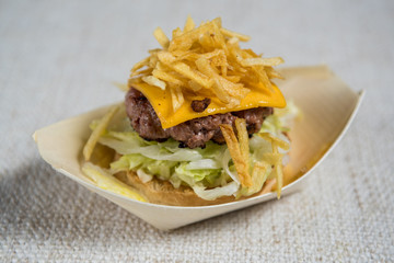Detail of a little hamburger with lettuce cheese and chips
