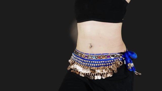 Closeup of woman belly dancing zumba in the studio with dark background. Shot in 4k resolution