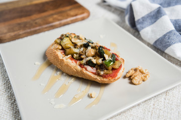 Spanish vegetarian tapas baked vegetables on bread with sauce. Eggplant, chickpeas view from above.