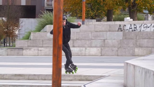 Skater jumps on roller blades in high stairs in slow motion