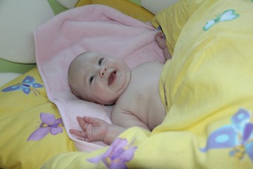 the baby is lying in a yellow crib