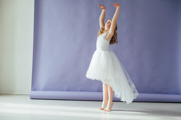 Girl in a dress dances to the music alone in the room