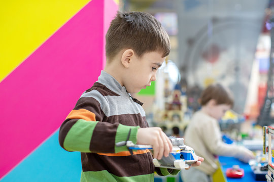2.5 years old little  toddler boy playing colorful toy block in Department store kid club.Motor skill and Executive functions concept.