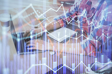 Multi exposure of forex graph with man working on computer on background. Concept of market analysis.