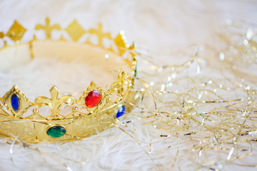 Royal gold crown with colored gems on white background.