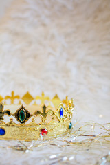 Golden crown with colored gems on a white background. Vertical.