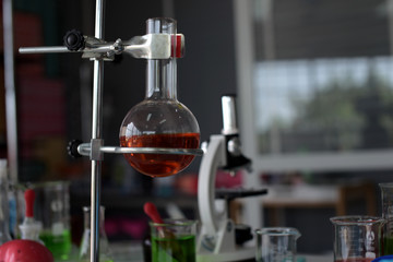 glass test tubes and flasks with colorful liquid on blue background with molecular structure