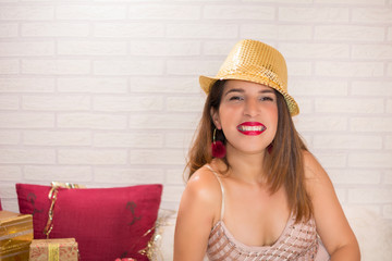 Portrait of a pretty smiling woman with golden cap enjoying and celebrating Christmas night.