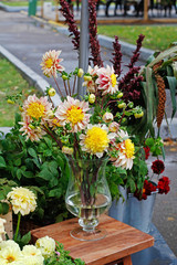 Yellow dahlias in a glass vase at market