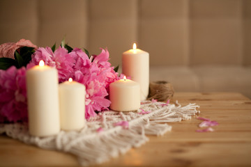 Fototapeta na wymiar Composition with blooming peonies and burning candles