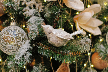 Silver Christmas toy bird hanging on the Christmas tree