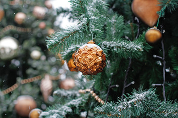 Golden ball with a pattern hanging on the Christmas tree