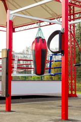 Image of an outdoor training room with punching bags of various shapes for martial arts. Healthy lifestyle concept.