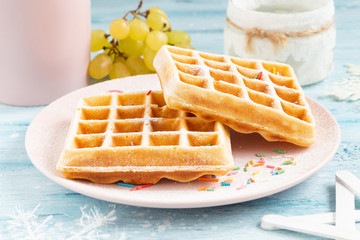 Belgian waffles with powdered sugar and confectionery sprinkles