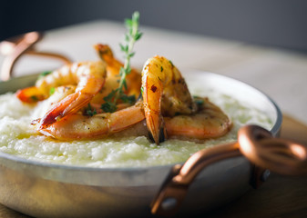 Shrimp and grits in a copper handled dish.  Copy space. 