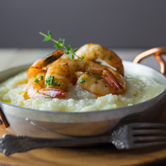 Shrimp and grits in a copper handled dish.  Copy space. 
