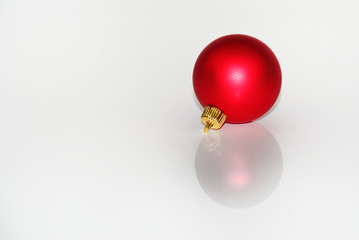 Red christmas ball reflecting on white background