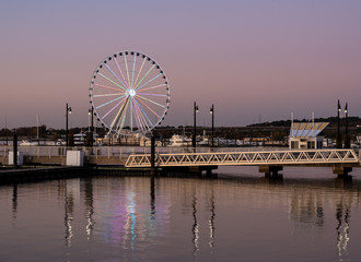Illuminated ferris wheel at National Harbor near the nation capital of Washington DC at sunset