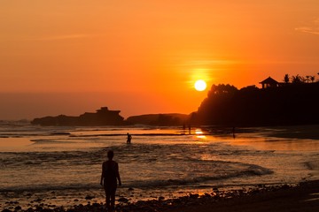 Fototapeta premium silhouette of woman on beach at sunset