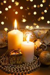 Christmas ornaments over dark golden background with lights.