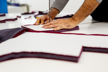 Cutter on cloth textile factory works with cutting machine.