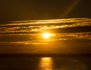 Scenic orange sunset sky background with sun on horizon above sea