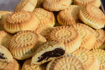 Close up of traditional oriental sweet pastry cookies known as mamul, Turkish desert with sugar,  walnuts and dates, in display at an weekend street food market, top view, soft focus