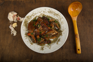 Dish of mushrooms chanterelles and the ladle and garlic