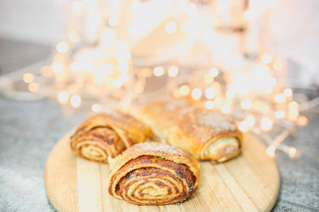 baked christmas strudel with apples on a background of lights.