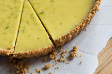 Slice of key lime pie with crumbly, sweet, graham cracker crust, close up view. 